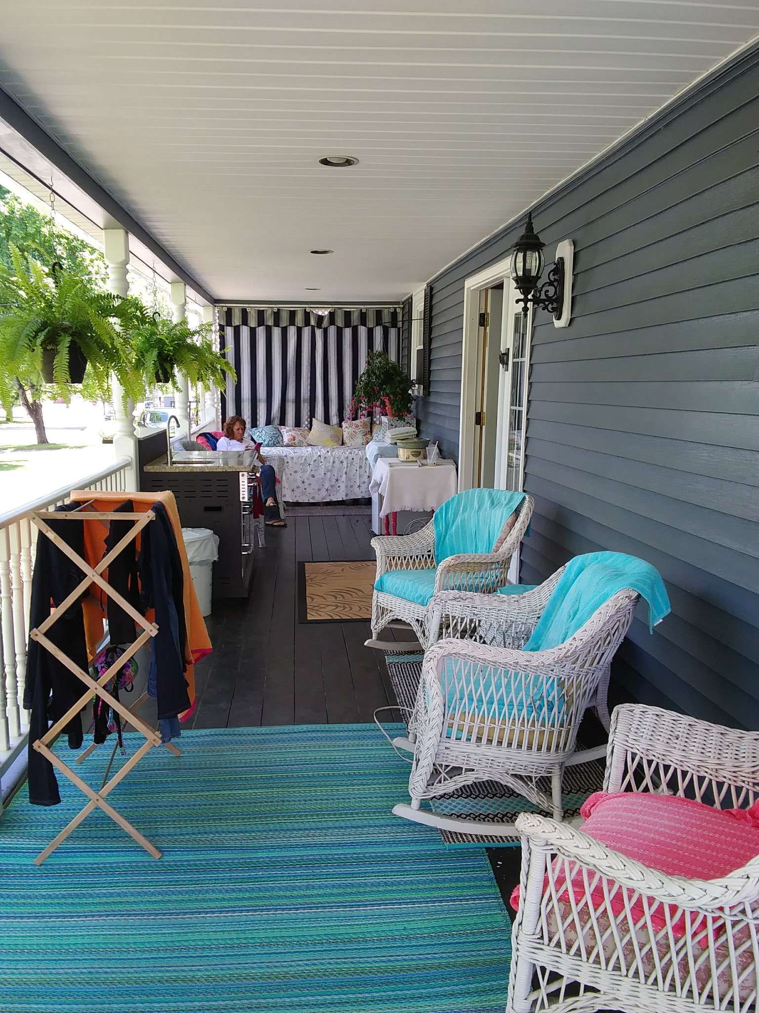 Covered porch with wicker furniture and hanging plants - perfect relaxation spot for contractors