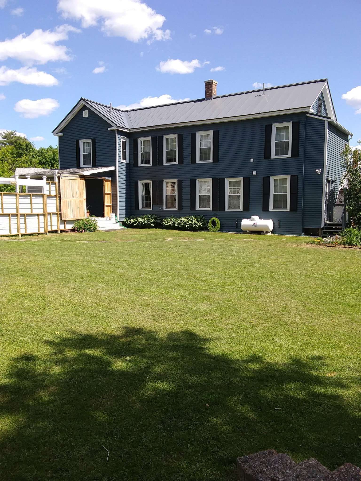 Back view of the house with spacious well-maintained lawn in Skowhegan - contractor housing