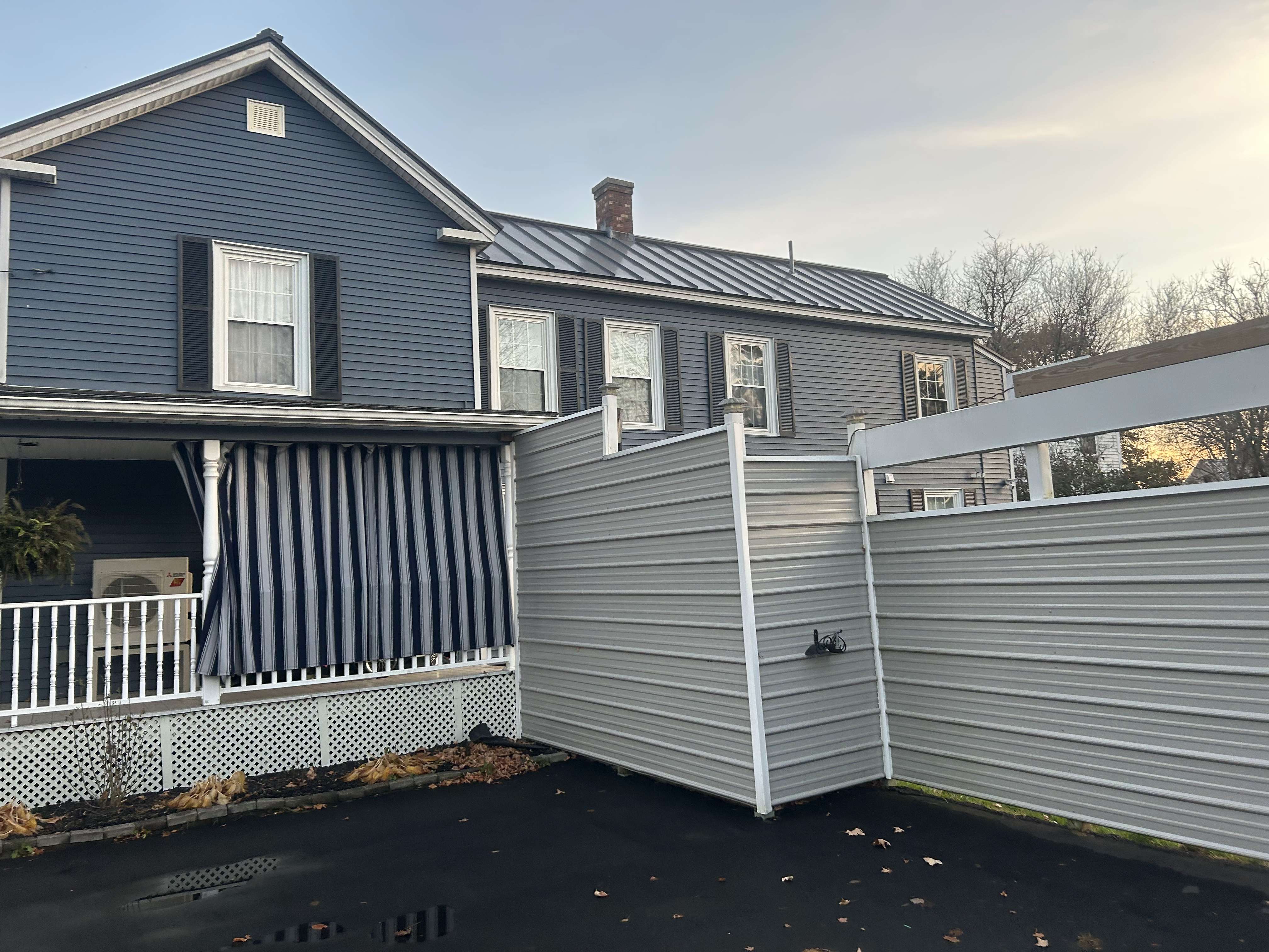 Side view of the house with privacy fence and porch curtains in Skowhegan - contractor rental